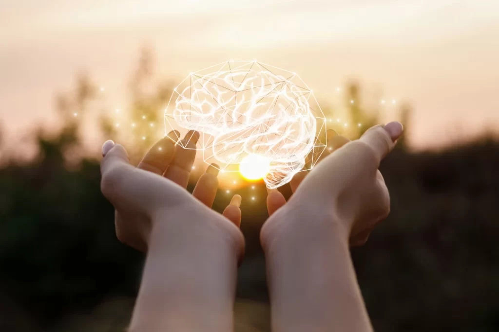beaming brain in girl\'s hand with sunset background